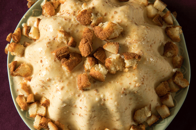Bitterkoekjespudding met bitterkoekjes op een bord